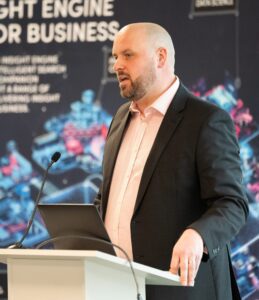 All Things Business Managing Director Ben Thomas standing at a podium discussing the official launch event for the Milton Keynes Education Awards