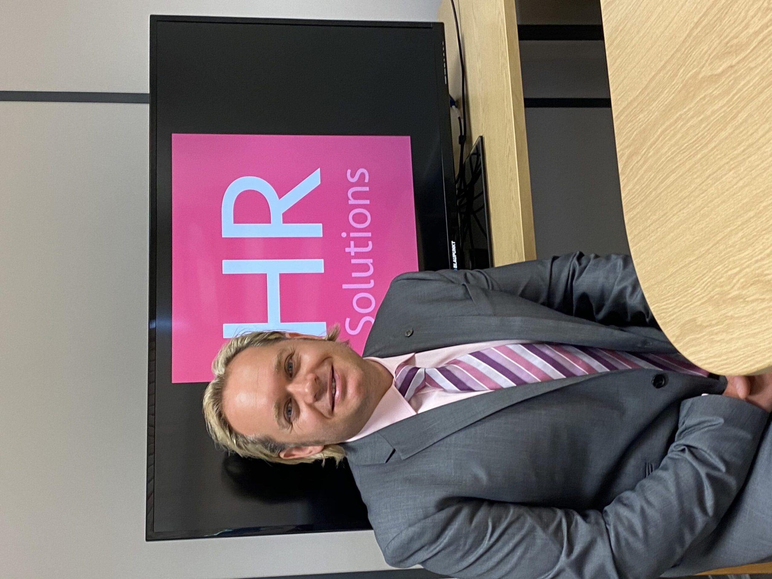 Dominic Greenwood with HR Solutions logo